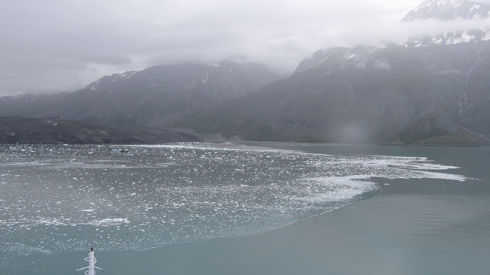 Ice-strewn water below the dark mountains at the head of Glacier Bay